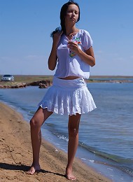 Sexy brunette teen posing bottomless on the beach